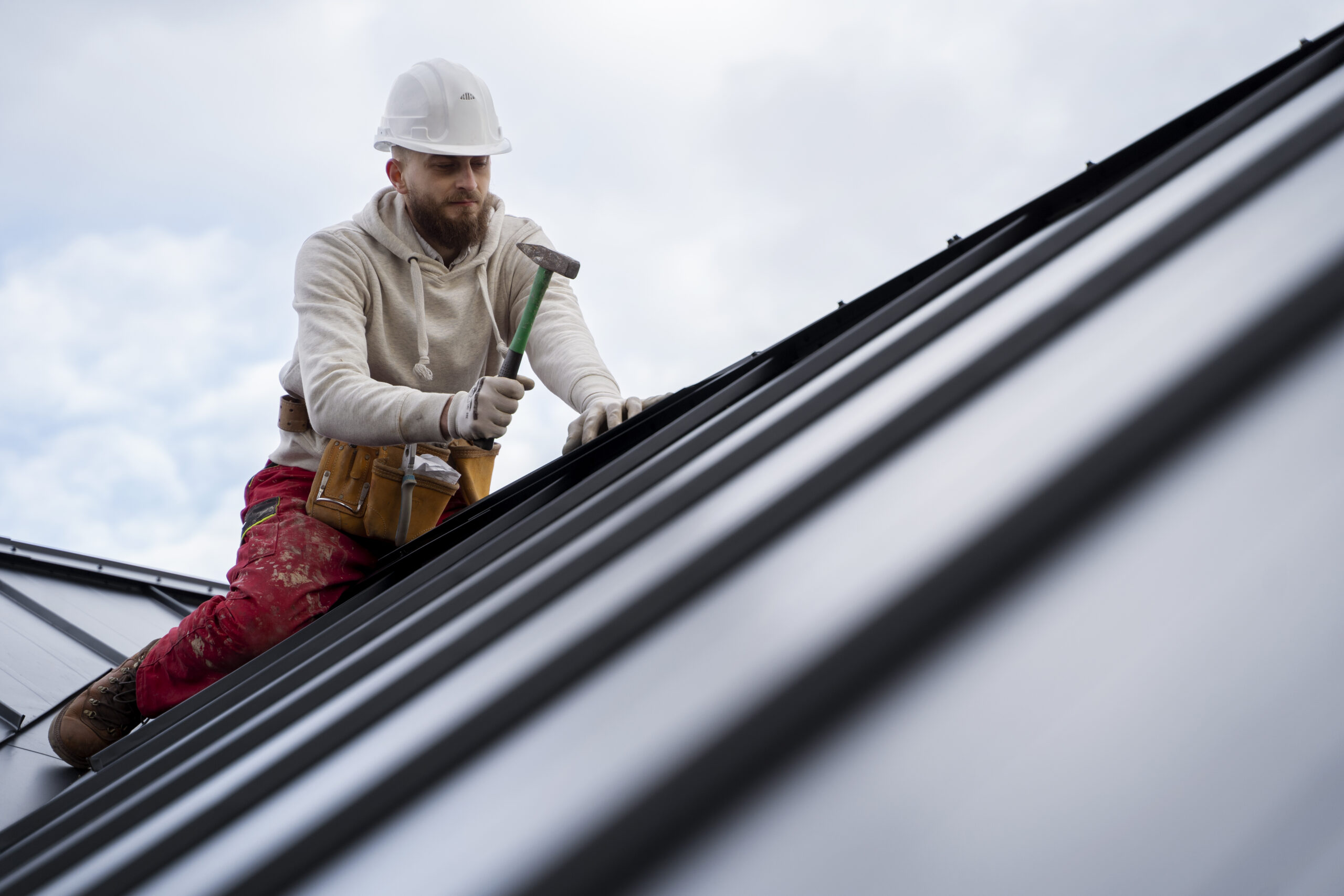 man-working-roof-with-hammer-full-shot